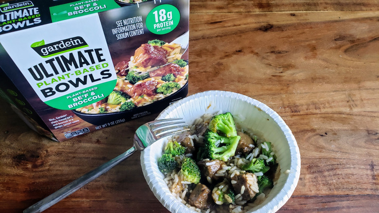Bowl of Gardein Plant-Based Be'f & Broccoli on wooden table with fork