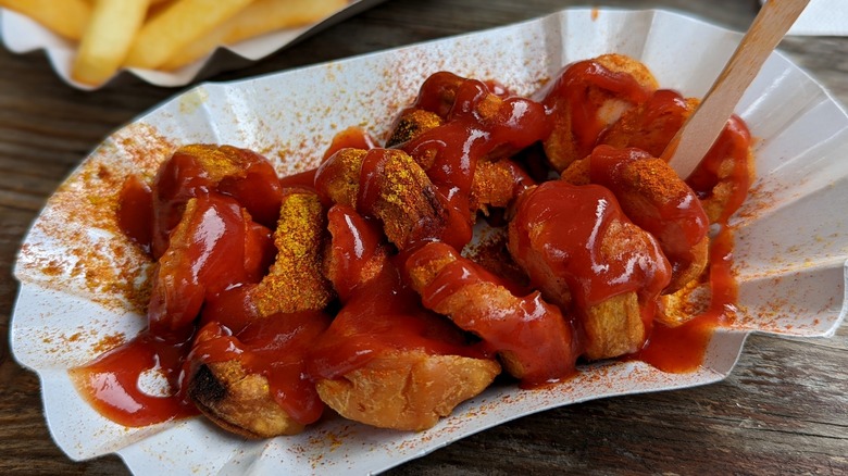 sliced currywurst in takeout dish