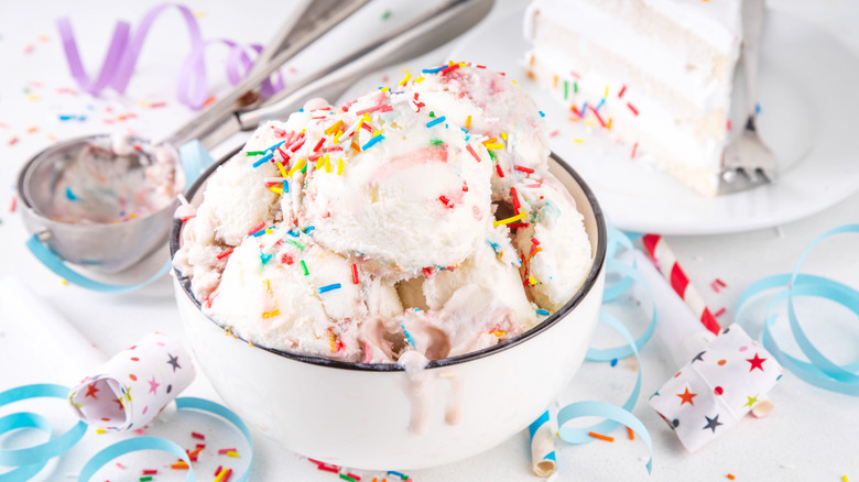 Multiple scoops of birthday cake ice cream with sprinkles in a bowl