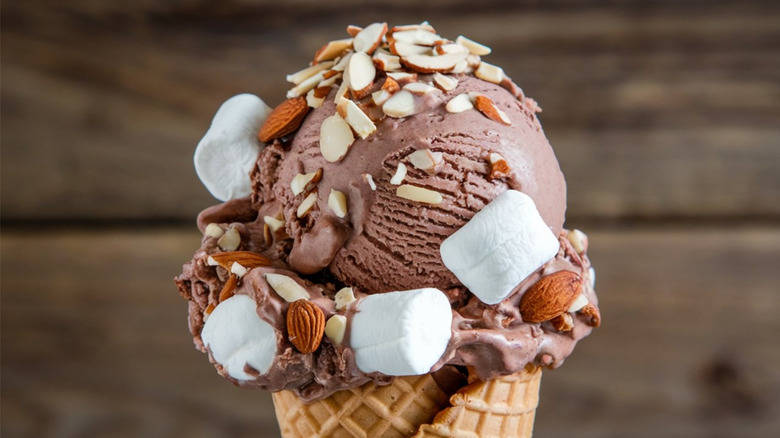 A waffle cone with rocky road ice cream - chocolate encrusted with nuts and marshmallows