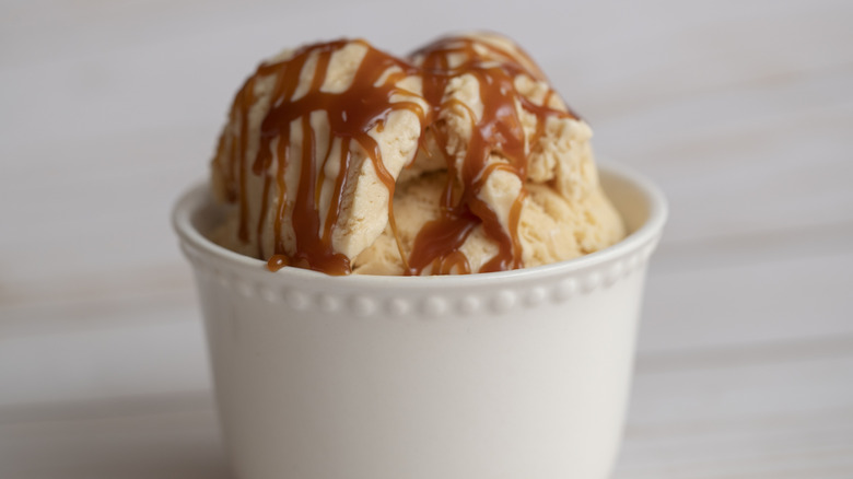 A cup of salted caramel ice cream with a caramel drizzle