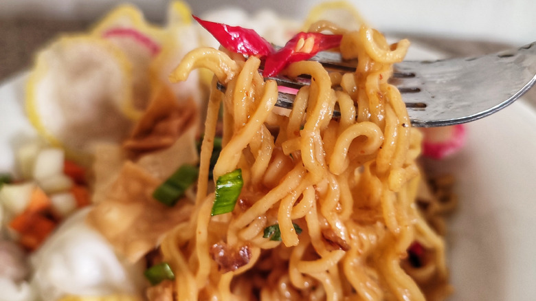 Lifting forkful of Mie Goreng from plate