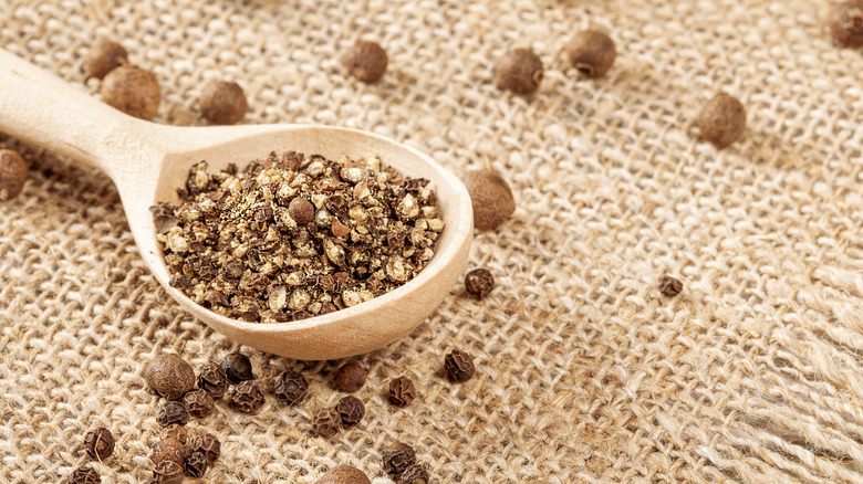 Freshly ground pepper on wooden spoon