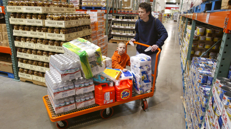 Family shopping at Costco, kid riding in cart