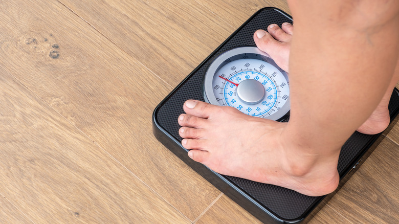 Feet standing on scale in bathroom