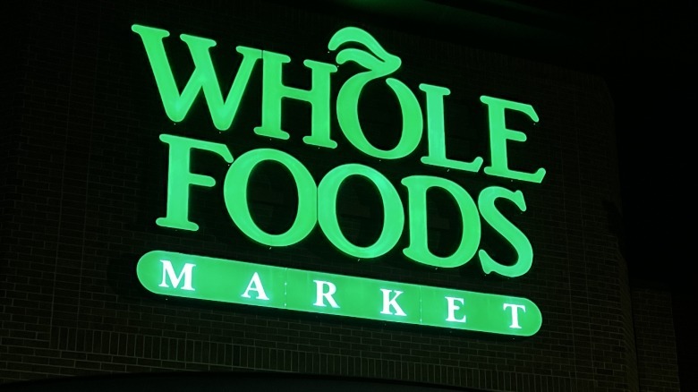 Lit up green Whole Foods sign on building
