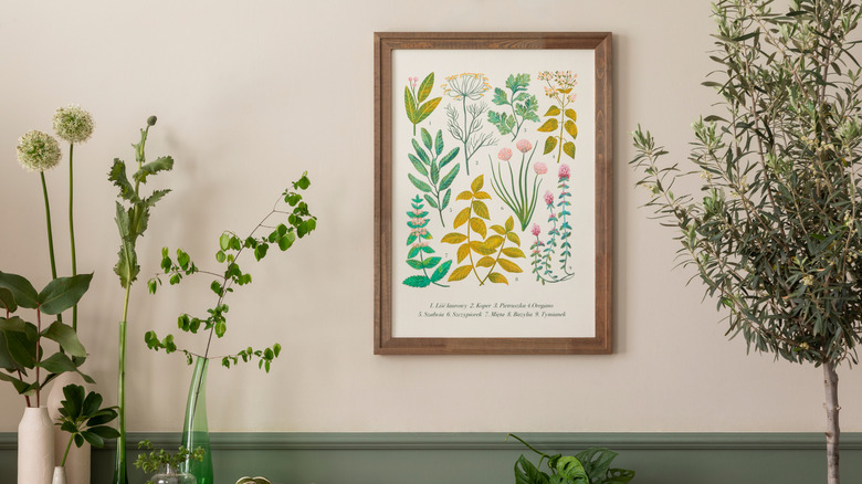 Framed poster of botanical wall art amidst various plants and vases