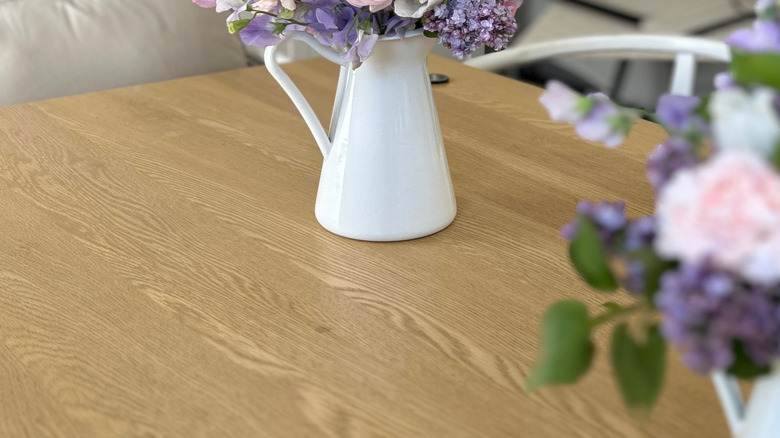 Pastel flower bouquet in a vintage pitcher on a wooden table