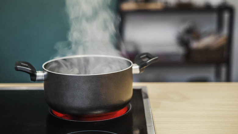 Boiling hot pan will steam rising on a hot electric stove.