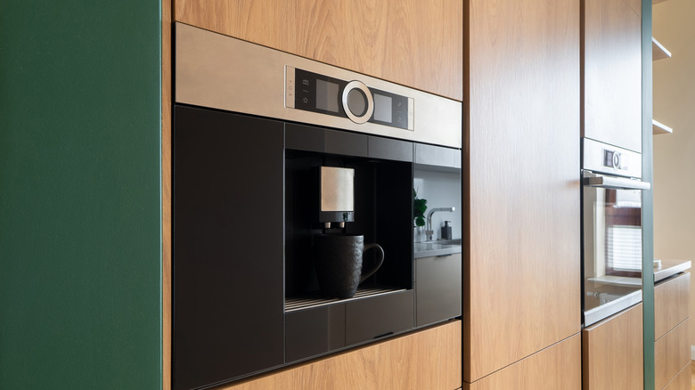 Built-in coffee machine and oven integrated into wooden cabinets
