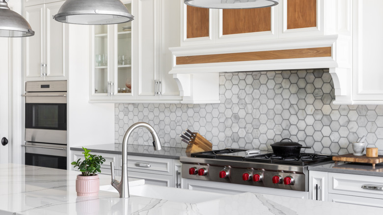Marble kitchen island with sink in a white kitchen