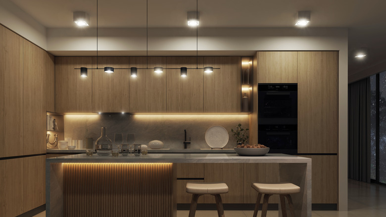 Kitchen with ceiling lights, hanging lights over an island, and under-cabinet lighting