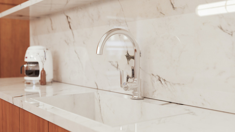Clean kitchen interior with marble backsplash and countertop
