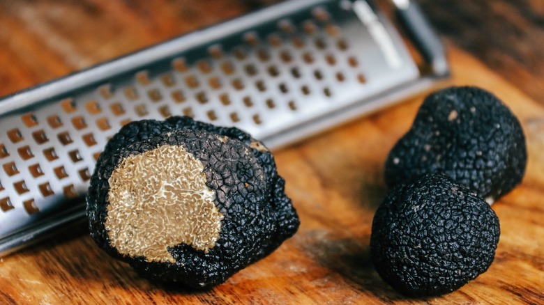 Close-up of black truffles in front of grater
