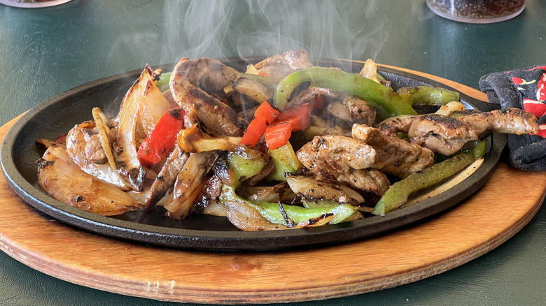Sizzling fajitas in a cast iron pan