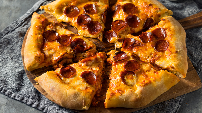 Stuffed crust pepperoni pizza on a wooden board
