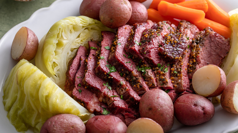 slices of corned beef surrounded by cabbage, carrots, and potatoes