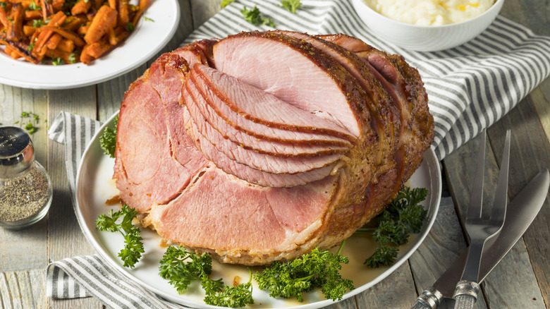 a spiral-cut ham on a platter with parlsey