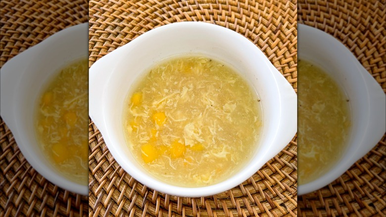Mirrored image of cabbage pottage in white dish on wooden mat