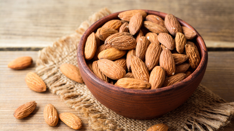 Bowl of almonds with some spilling out