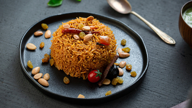 Individual portion of maqluba with golden raisins and almonds