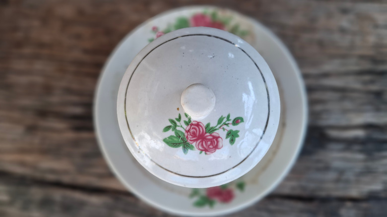vintage serving bowl and matching saucer, in an old-fashioned rose pattern, gleaming in a sunbeam