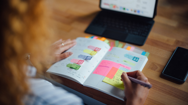 Photo over the shoulder of someone looking at a calendar planner