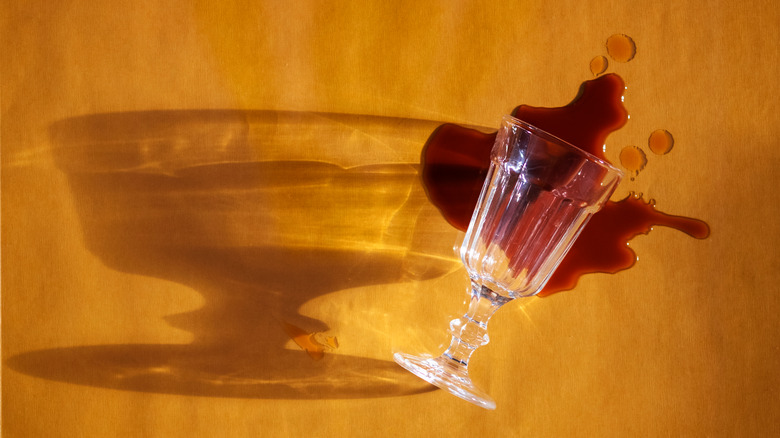 Spilled glass of wine on wood-textured surface
