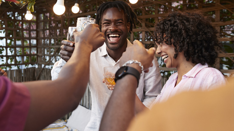 A group of people laughing and holding drinks