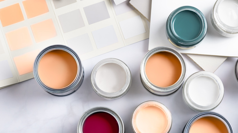 Tiny sample paint cans placed alongside color swatch cards