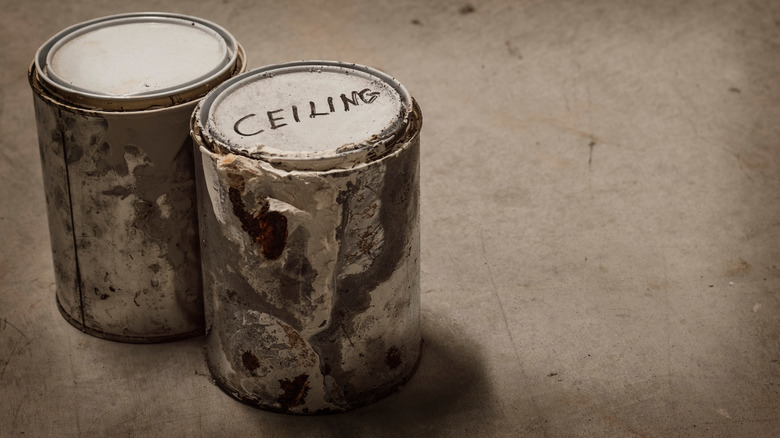 Paint cans with dried paint and one labeled ceiling