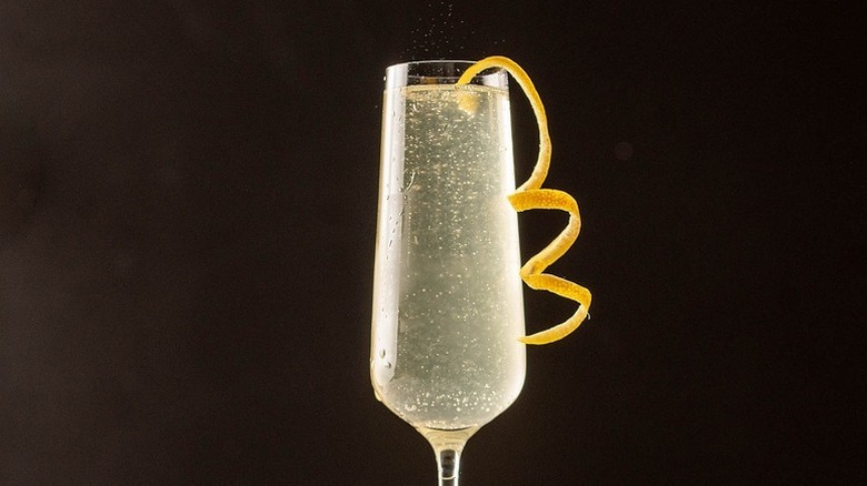 Champagne cocktail in champagne flute, garnished with lemon twist
