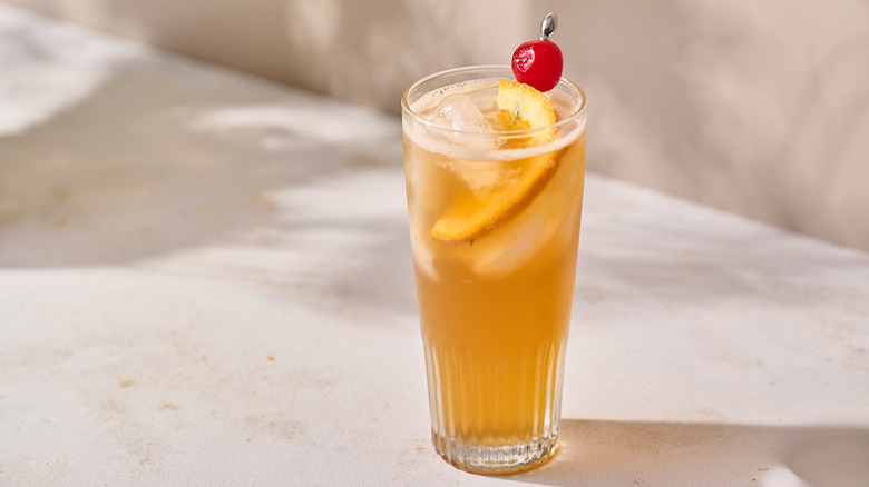 Mississippi punch in glass, garnished with orange slice and maraschino cherry