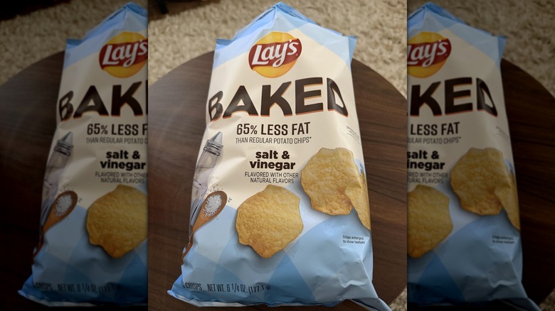 A bag of Lay's Baked Salt & Vinegar chips on a round wooden table