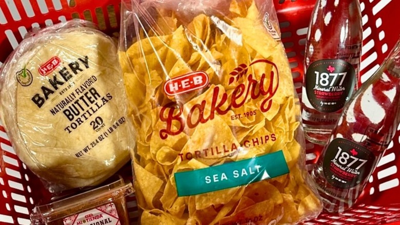 Grocery basket filled with a bag of H-E-B Bakery tortilla chips and other items