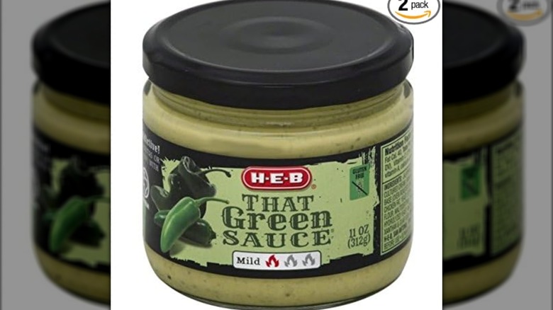 Mirrored image of a jar of H-E-B That Green Sauce on a white background