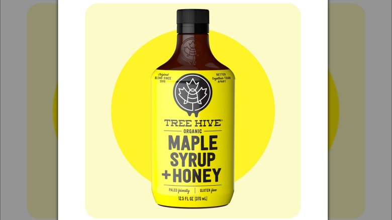 Bottle of Tree Hive maple syrup & honey on a white mirrored background