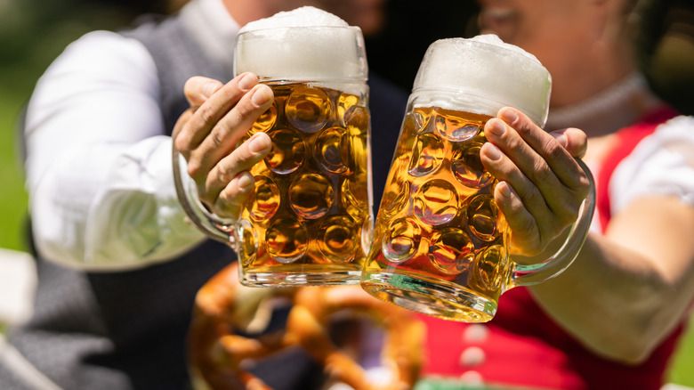 Two unidentified people holding large beer mugs