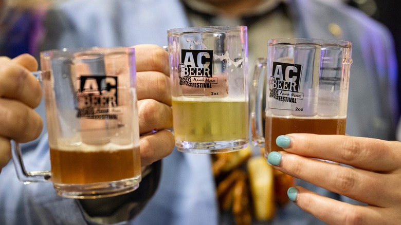 Hands holding beer mugs with Atlantic City Beer and Music Festival label