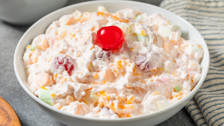 Southern style ambrosia salad with a cherry in a white bowl