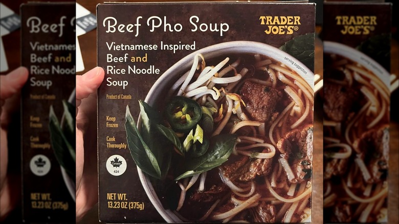 Hand holding box of Trader Joe's Beef Pho