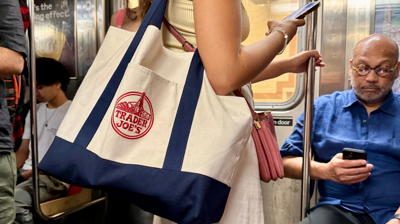 Unidentified person on subway with canvas bag from Trader Joe's