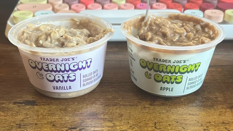 Containers of Trader Joe's vanilla and apple Overnight Oats open beside colorful kepyboard
