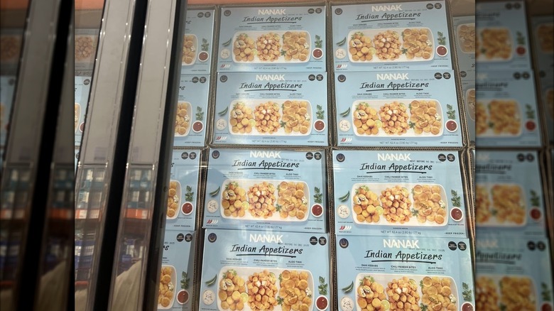 A Costco freezer case containing boxes of Nanak Indian Appetizers