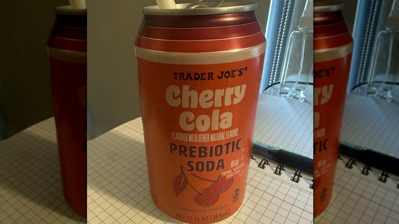 A can of Trader Joe's Prebiotic Cherry Cola sitting on notebook paper