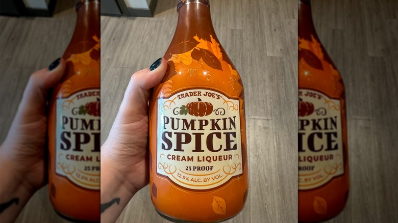 A person holding a bottle of Trader Joe's Pumpkin Spice Cream Liqueur