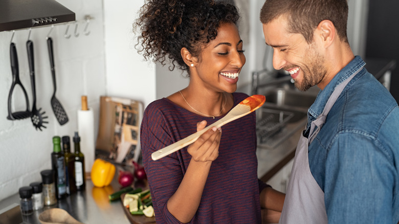 chef wearing gloves plating pasta