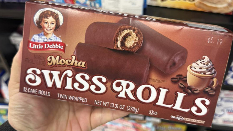 Hand holding box of Little Debbie Mocha Swiss Rolls
