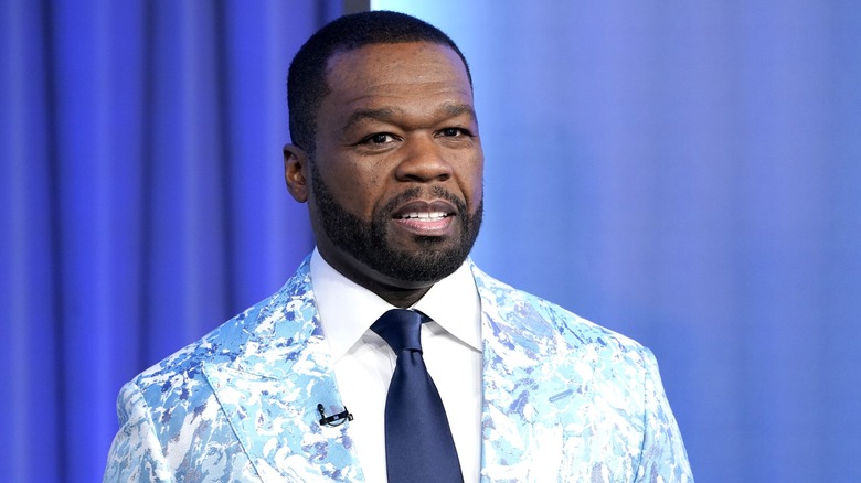 Curtis "50 Cent" Jackson in light blue suit against dark blue background