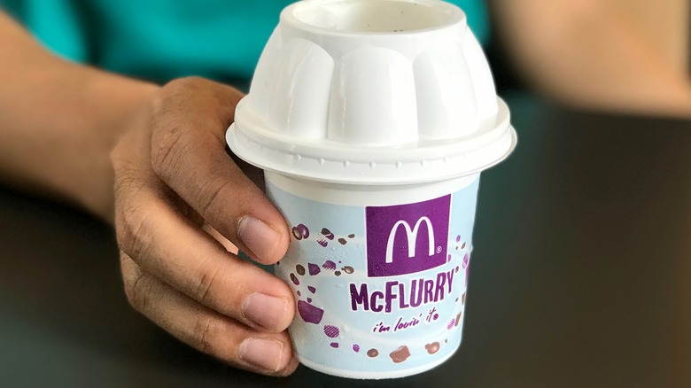 Hand holding Mcdonald's McFlurry ice cream